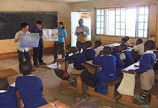 小学生を対象に日本の自慢を紹介。テマ村内に存在するオリモ小学校の小学生を相手に、写真を利用して日本の自慢を紹介している様子。担当の先生にスワヒリ語・英語の通訳としての協力を得た。