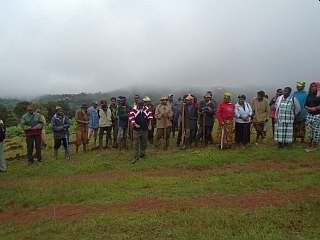 今にも雨が降り出しそうな天気の中、植林地に集まってきた村人たち